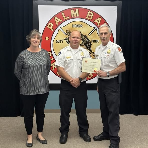 Brandon McKee receiving a Palm Bay Fire Rescue promotion certificate from city officials